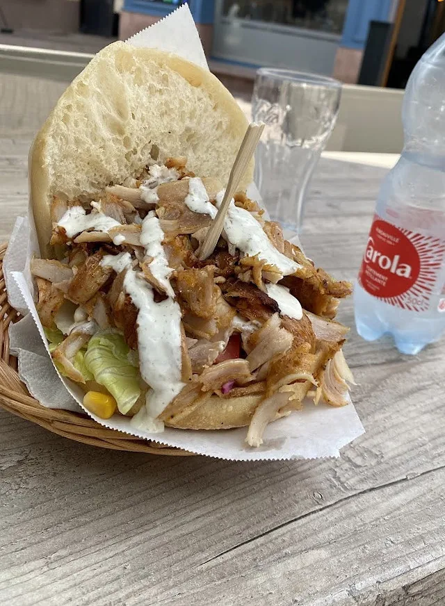 Sandwich kebab dans son pain, servi en terrasse